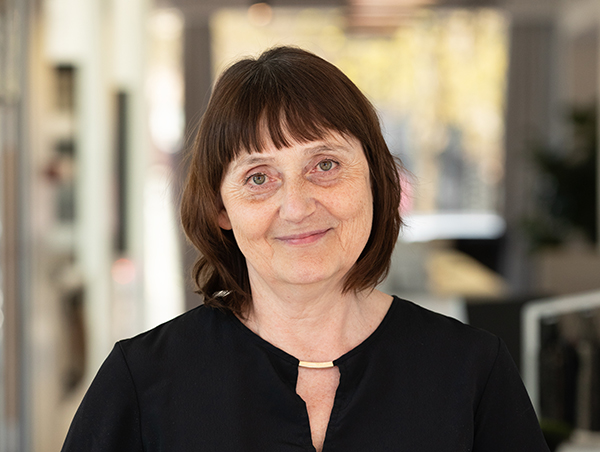 Naeratav naine kontoris mustas särgis seismas.