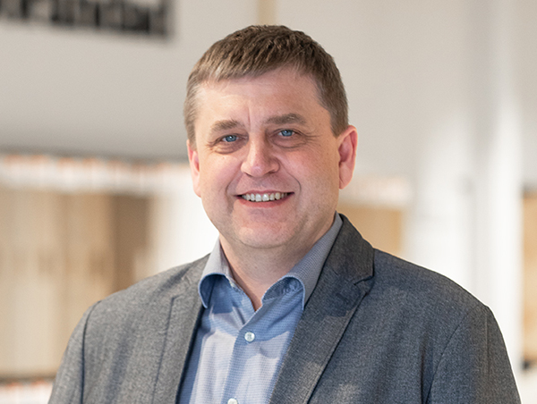 Mees hallis ülikonnas naeratamas kontoris töötamine