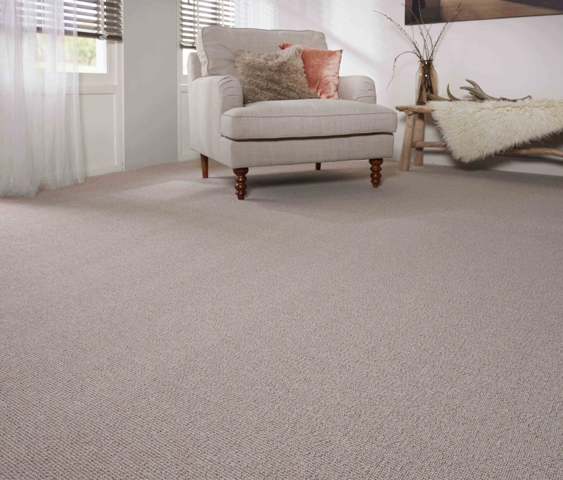 Beež diivan valgusküllases elutoas pehmel vaibal