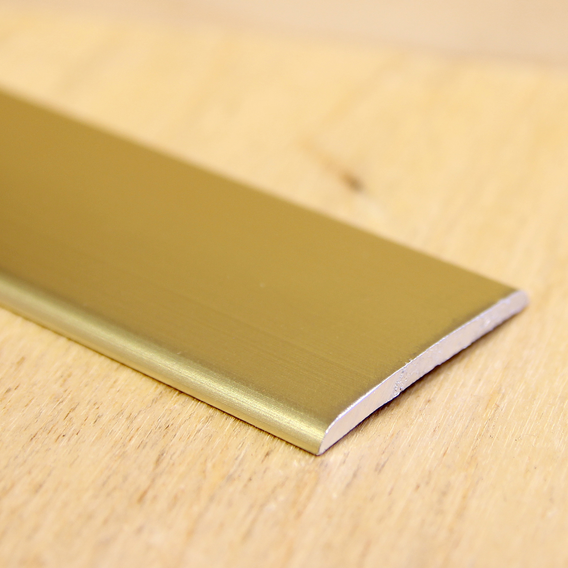 Kuldne põrandaliist puidust pinnal lähedalt