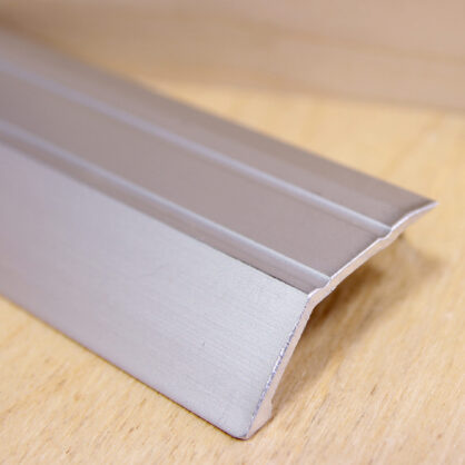 Hõbedane alumiiniumprofiil puidust pinnal lähedalt