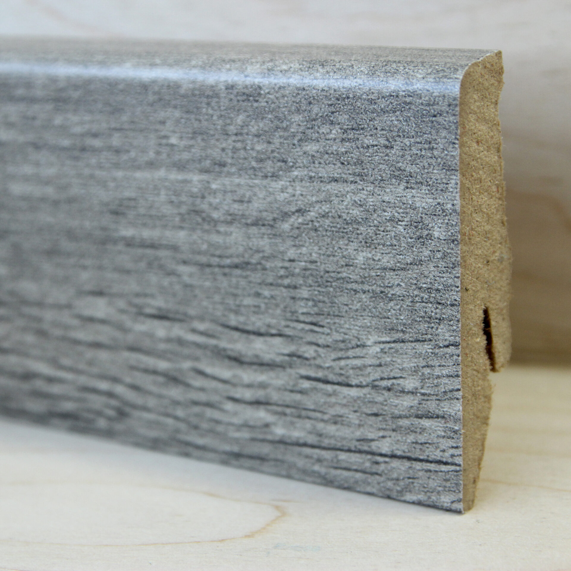 Puidust tekstuuriga hall põrandaliist lähedalt.