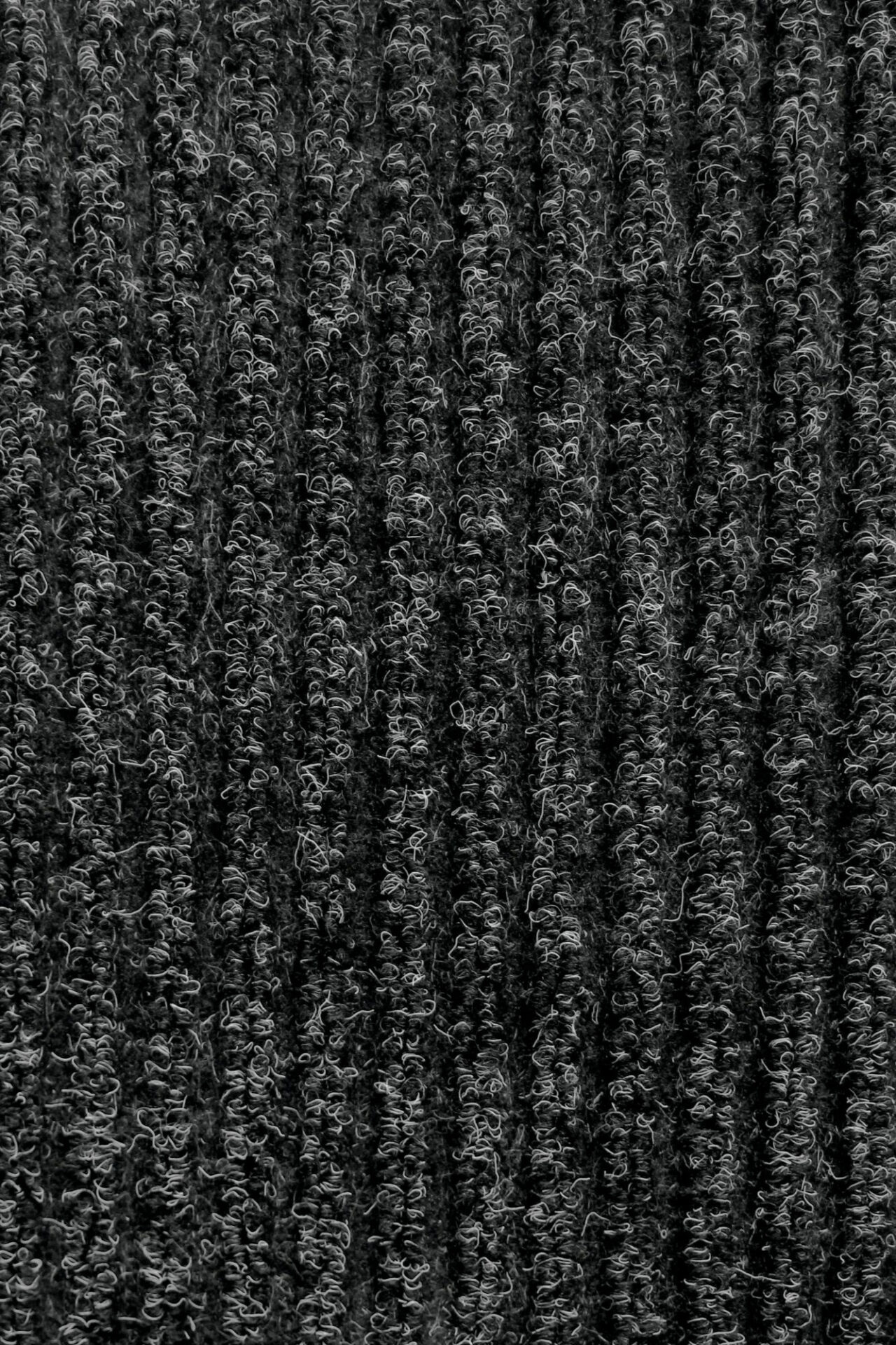 Tumedat värvi tekstuurne vaip lähedalt vaadatuna