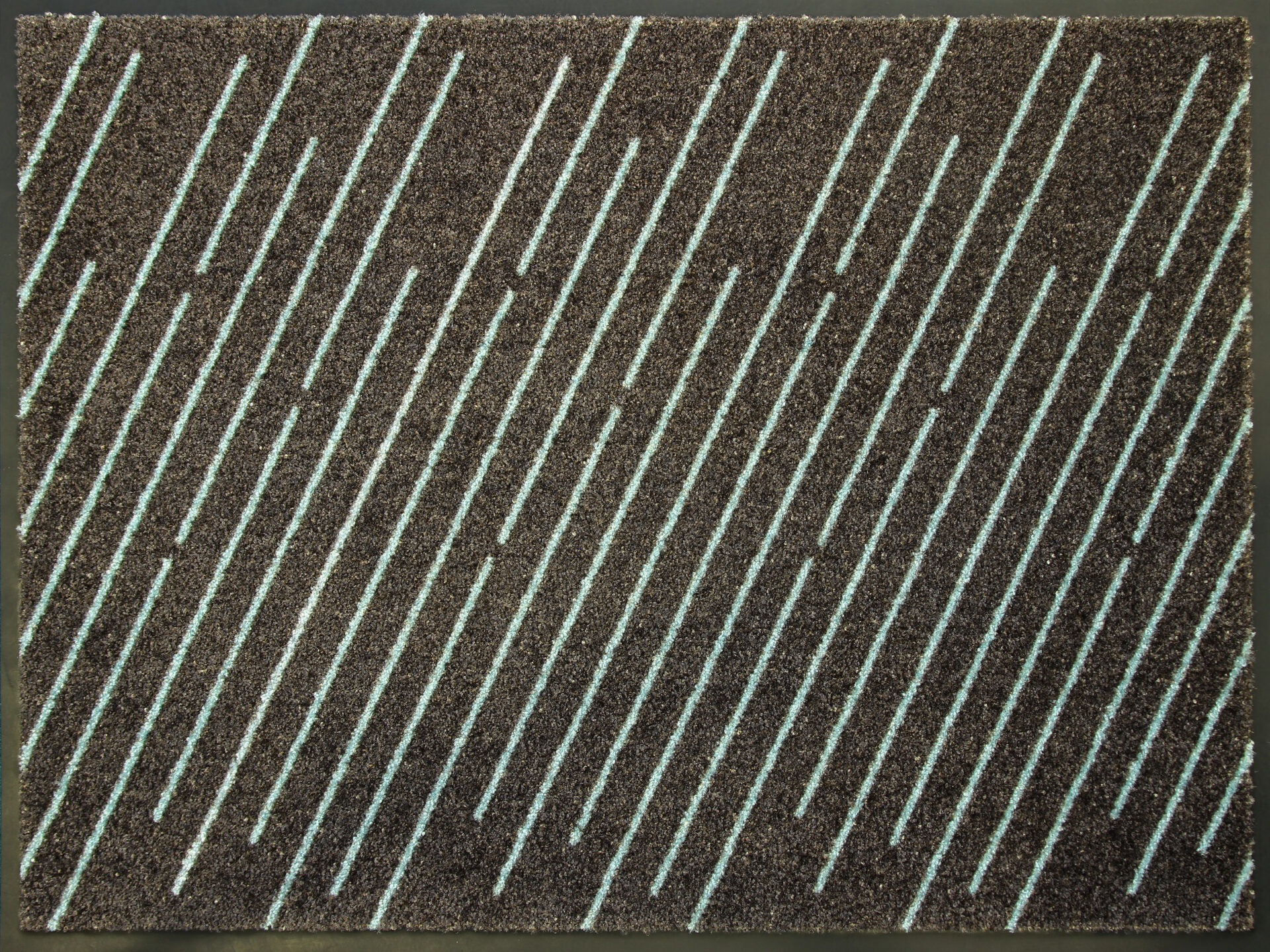 Pruun vaip sinise triibulise mustriga põrandal