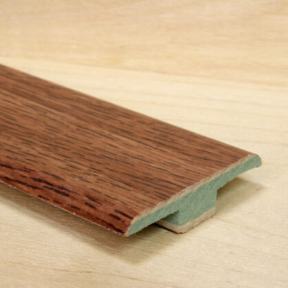 Puidust põrandaliistu profiil puidust taustal.