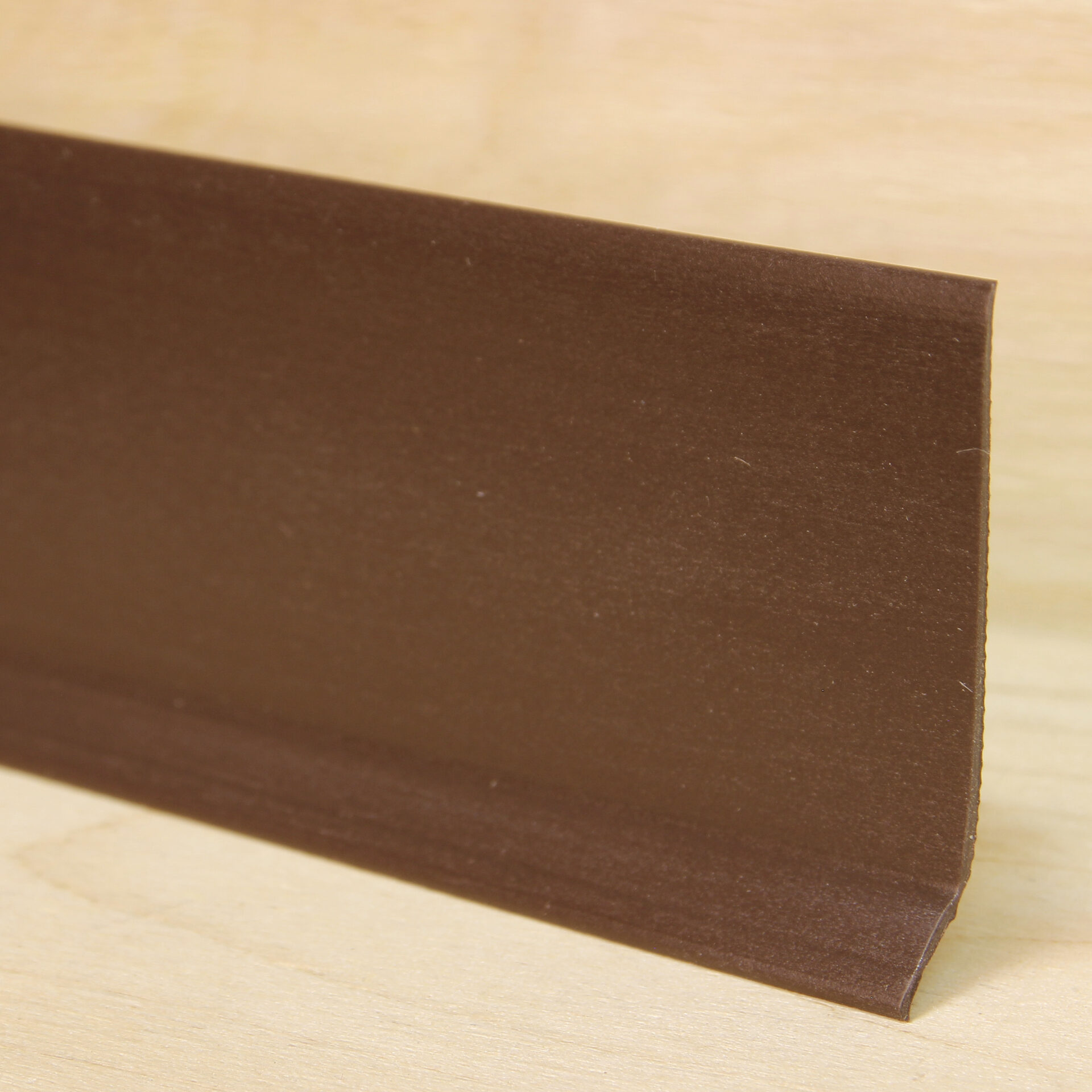 Pruuni värvi põrandaliist puitpõrandal lähivaade