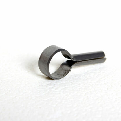 Metallist torukujuline ese valgel taustal asetatud.