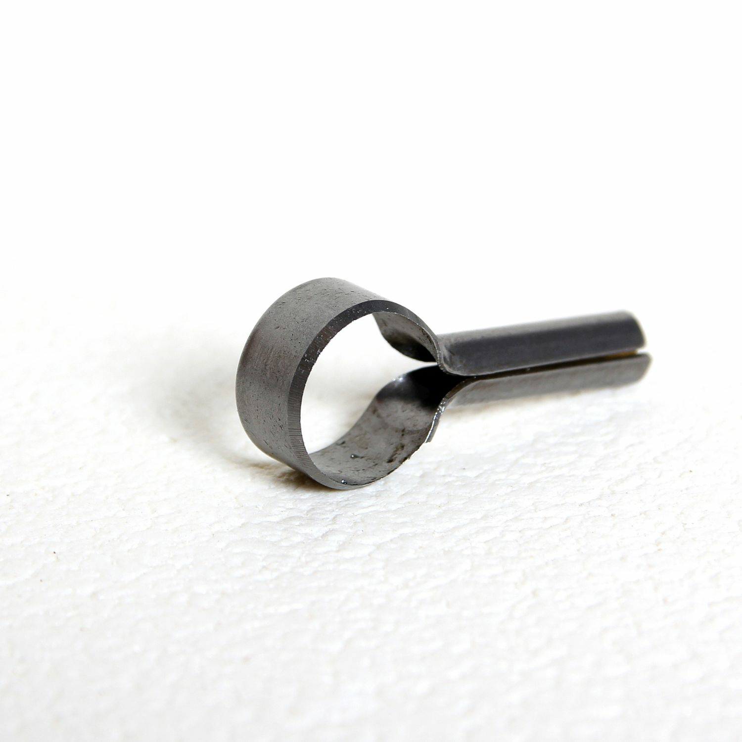 Metallist torukujuline ese valgel taustal asetatud.