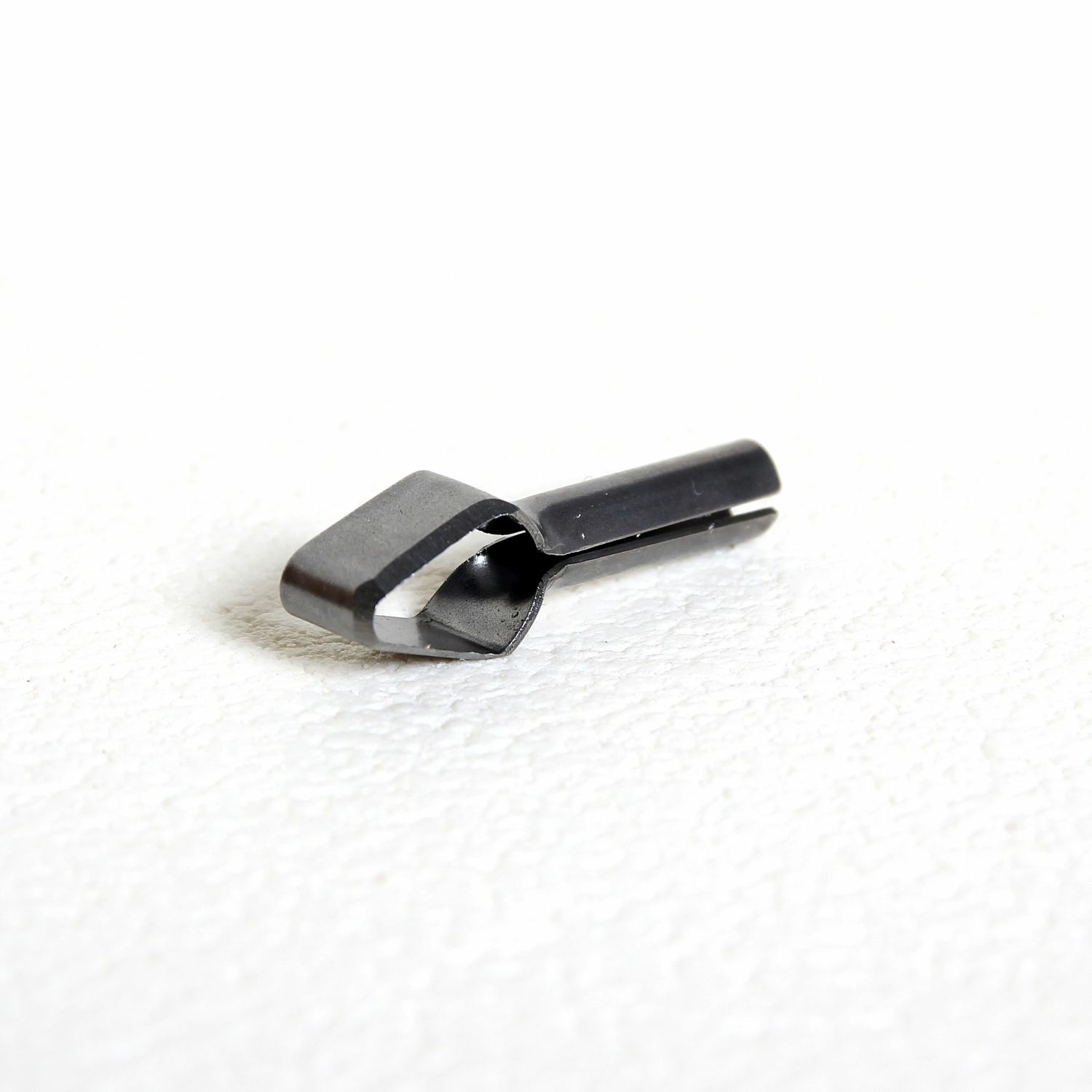 Musta metallist tööriist valgel taustal.