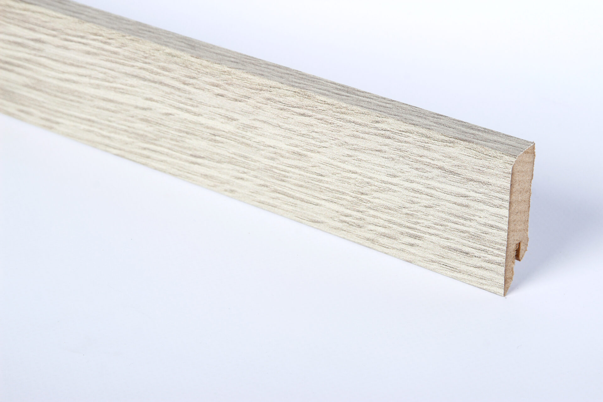 Valge puidust põrandaliist lähivaates kuvatud.