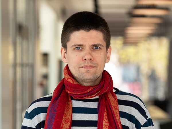 Noormees triibulises särgis ja punases sallis.