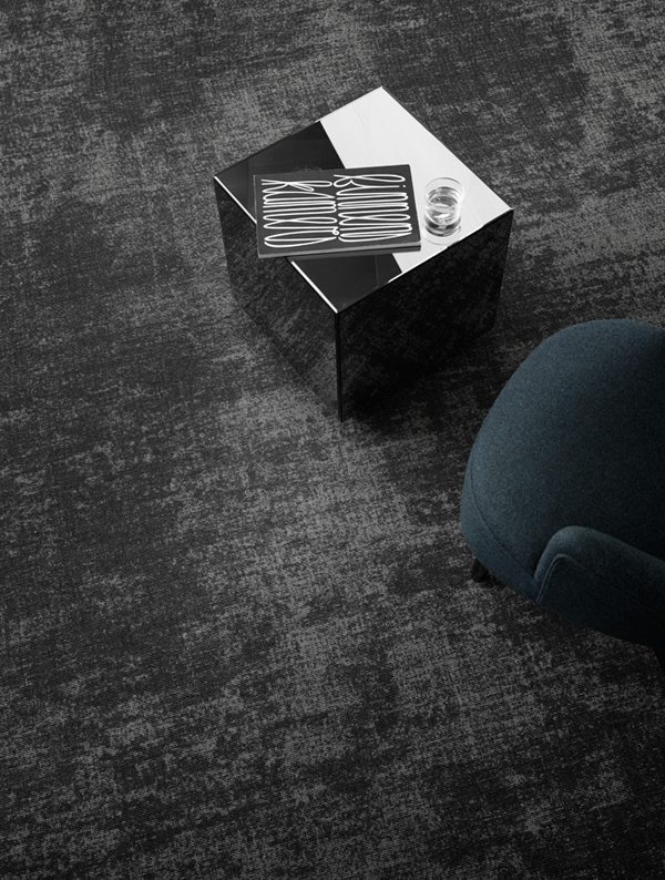 Tume vaip kohvilaua ja tugitooliga ruumis