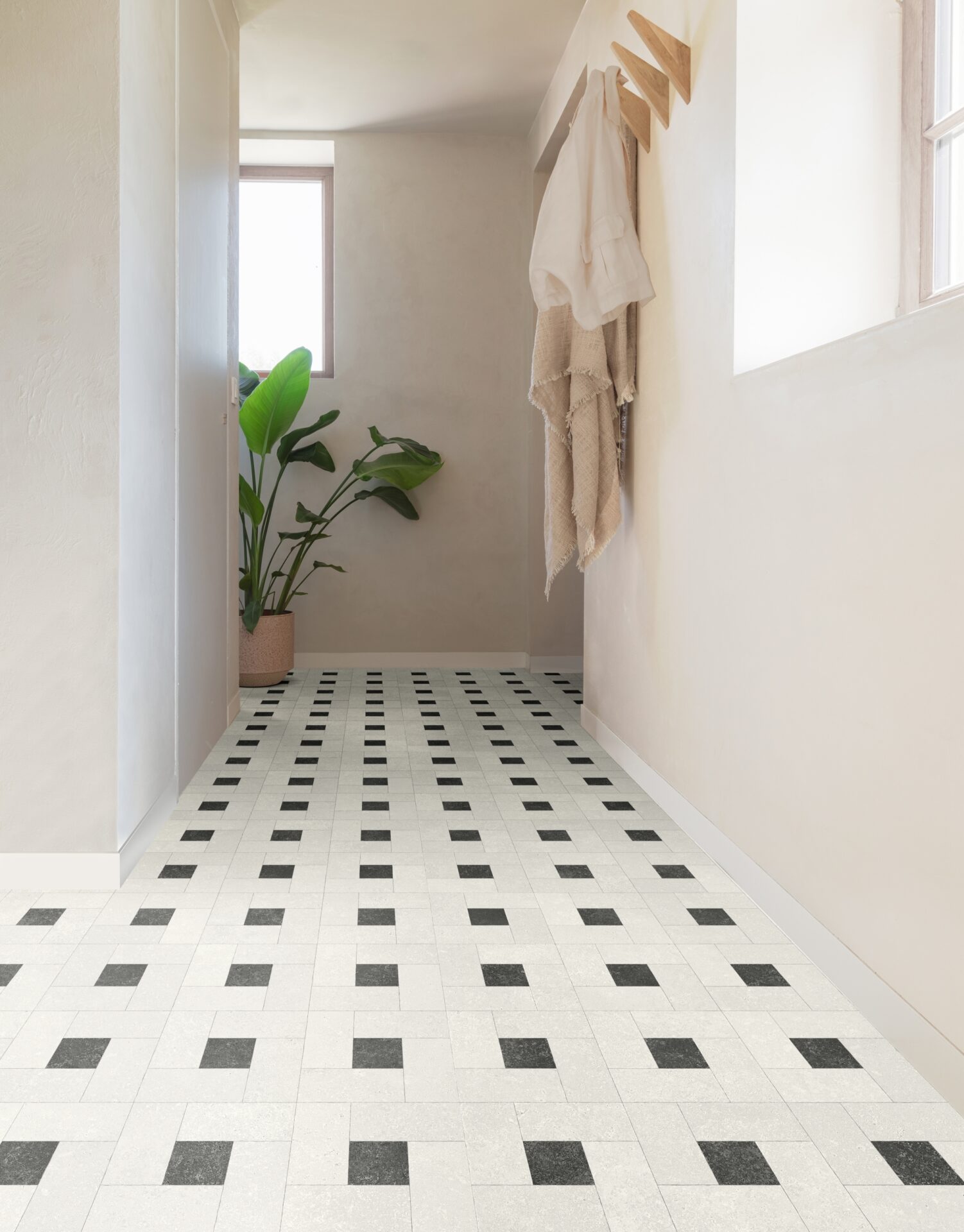 Koridor mustade valgete plaatide ja taimedega