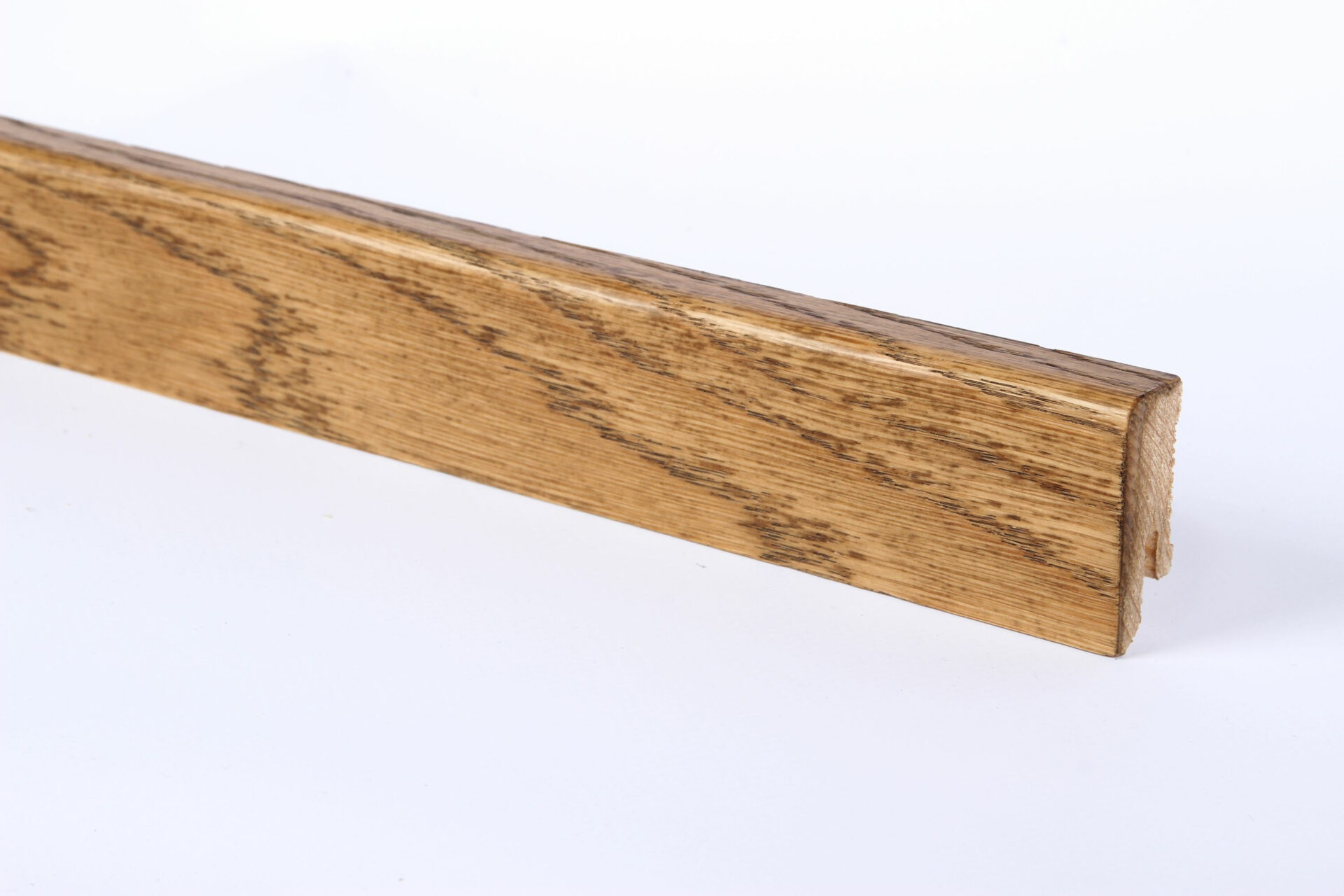 Pruun puidust liist valgel taustal.