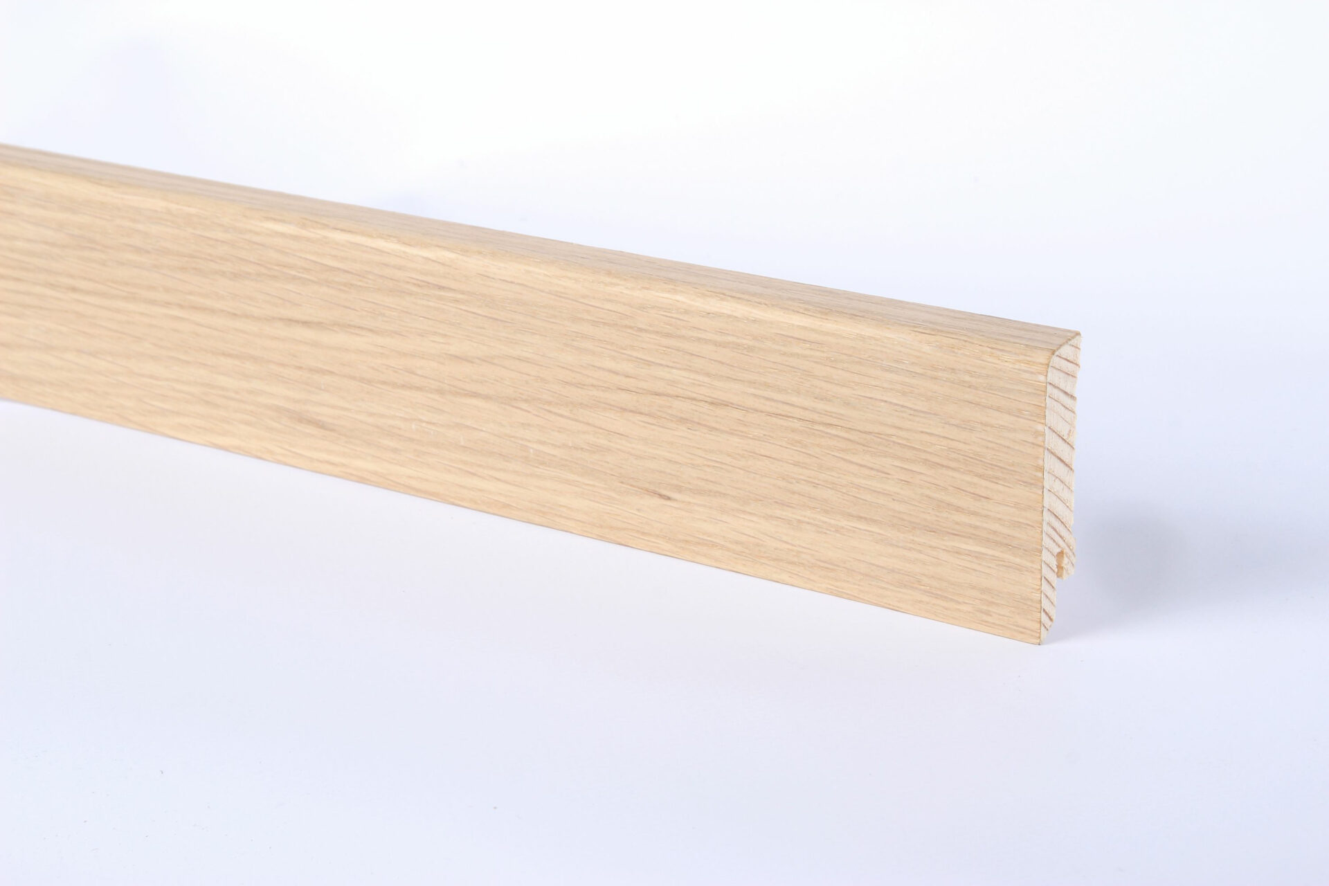 Puidust põrandaliist heleda puitviimistlusega lähedalt.