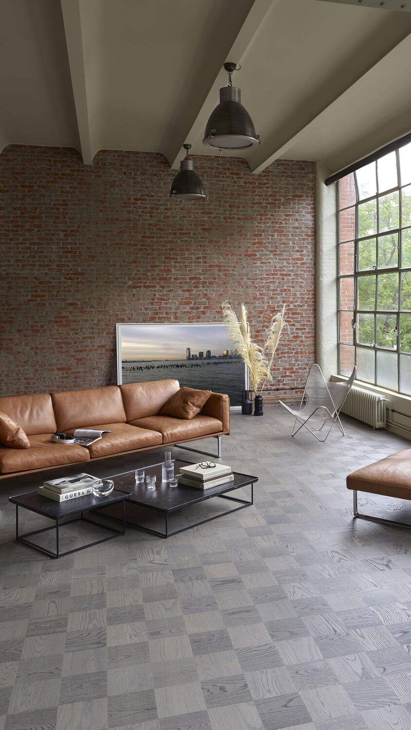 Moodsne elutuba pruunide diivanite ja telliskiviseinaga