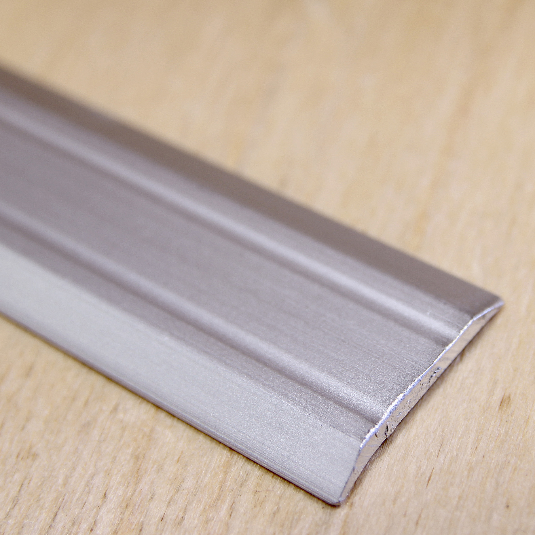 Alumiiniumprofiil puidust pinnal lähedalt vaadatuna