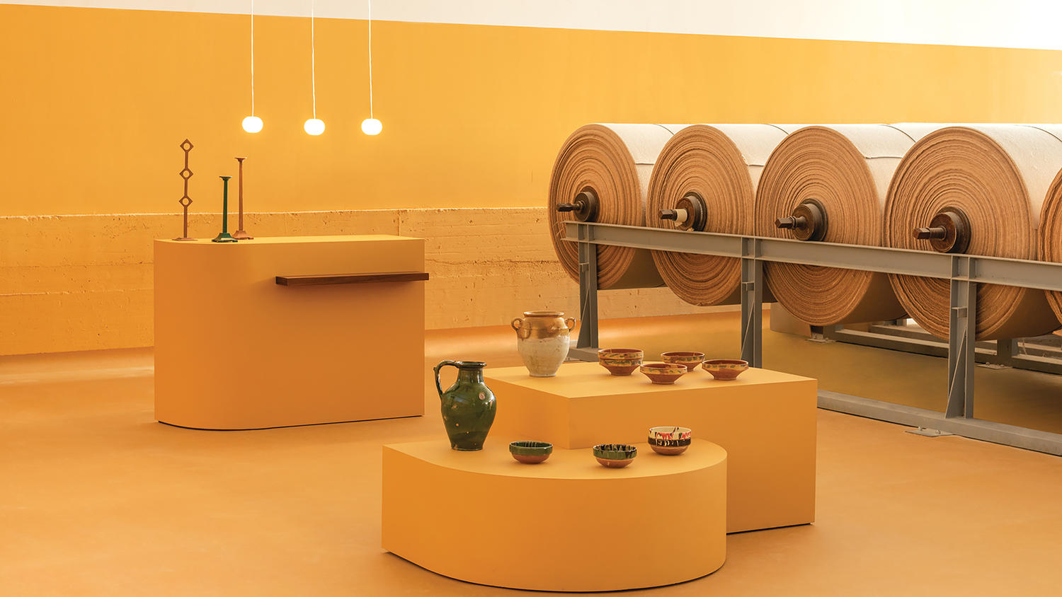 Kaasaegne galerii kollases näitusetoas keraamikaga.