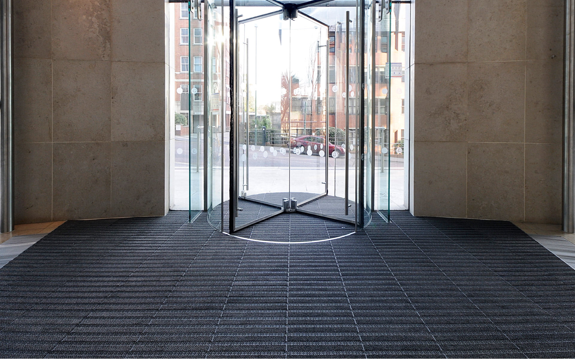 Pöörlev uks ja esiku matt hoone sissepääsul