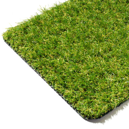 Kunstmuru tükk detailse rohelise rohuga peal